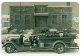 Vintage car parked in front of an old brick building.