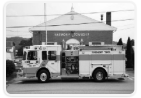 Black and white photo of a fire truck parked on a city street.